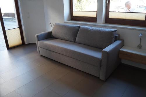 a couch in a living room with two windows at FEWO Außerlechner in Innsbruck