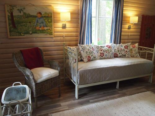 1 dormitorio con 1 cama, 1 silla y 1 ventana en Tammiston Cottages, en Naantali