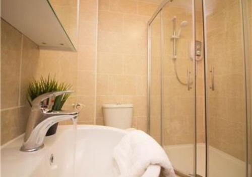 a bathroom with a shower and a sink and a sink at StayZo Stylish Accommodation in Southampton 10 in Southampton
