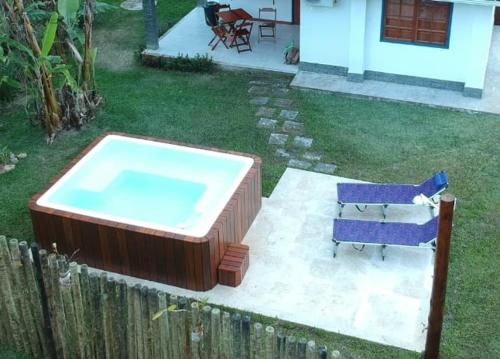 a hot tub in a yard next to a house at A Casinha Lumiar in Lumiar