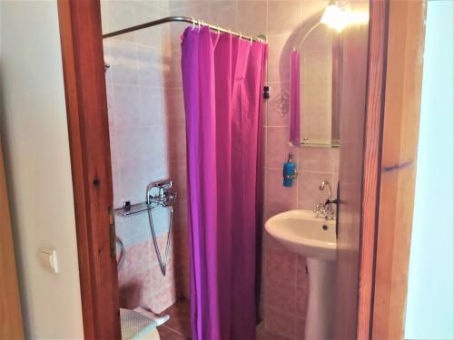 un bagno con tenda doccia rosa e lavandino di Diporto a Chania