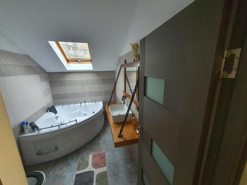 a bathroom with a large tub and a sink at Comfort Home Studio in Petroşani