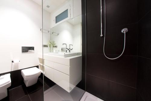 a bathroom with a shower and a toilet and a sink at Avenida La Concha - IB. Apartments in San Sebastián