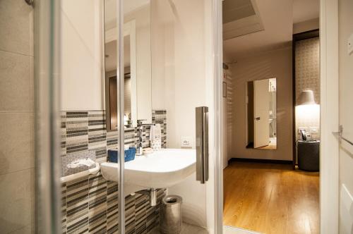 a bathroom with a white sink and a mirror at Fly Decó Hotel in Lido di Ostia