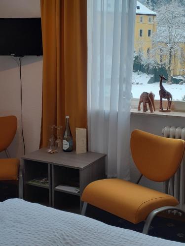 a bedroom with a bed and two chairs and a window at Haus S.E.E. in Marienthal