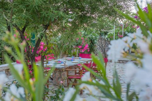 a table and chairs in a garden with pink flowers at Seafront Paradise in Glífa