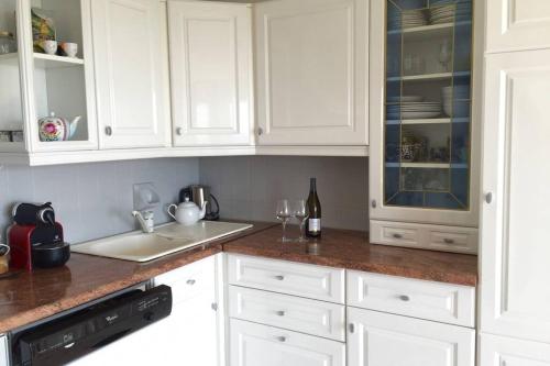 une cuisine avec des placards blancs et un comptoir dans l'établissement Vue panoramique sur le vignoble, à Sancerre