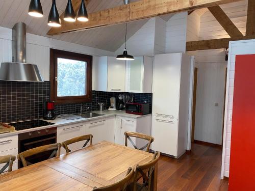 a kitchen with a wooden table and a dining room at Le Cap Vert in Rochehaut