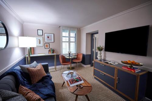 a living room with a couch and a flat screen tv at The Oliver Hotel Knoxville, by Oliver in Knoxville