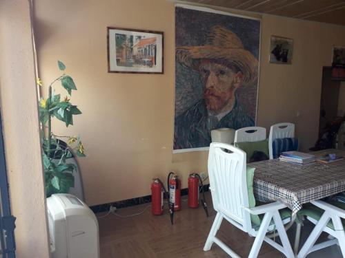 a dining room with a table and a painting of a cowboy at Afilux Residencial in Luanda