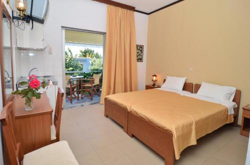 a hotel room with a bed and a balcony at Polizotou Rooms in Skala Sotiros