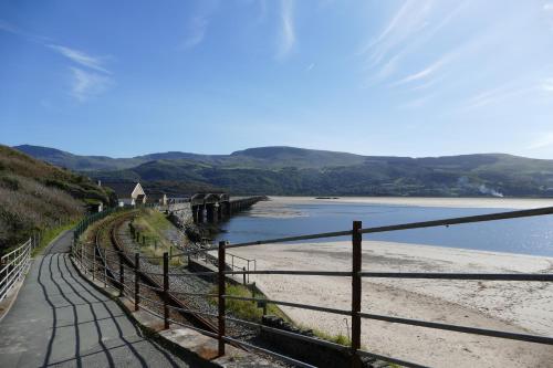 a train crossing a bridge over a body of water at Bae Abermaw Hotel in Barmouth