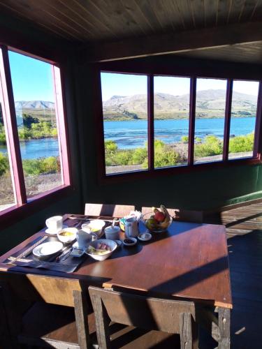 a dining room table with a view of the water at La Berendina in Huechulafquen Lake