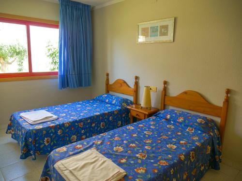 1 dormitorio con 2 camas y ventana en Apartments Kione Playa Romana Park, en Alcossebre