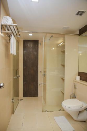 a bathroom with a toilet and a glass shower at Citrus Prime Raipur in Raipur