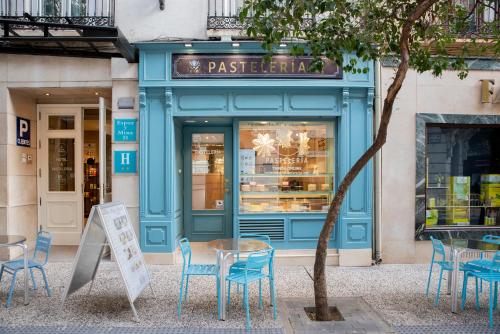a blue store front with tables and chairs in front of it at Hotel Sauce in Zaragoza