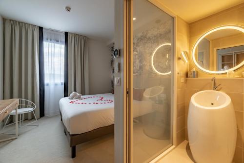 La salle de bains est pourvue d'une douche, d'un lit et d'un lavabo. dans l'établissement Brit Hotel Ker Lann Aeroport, à Bruz