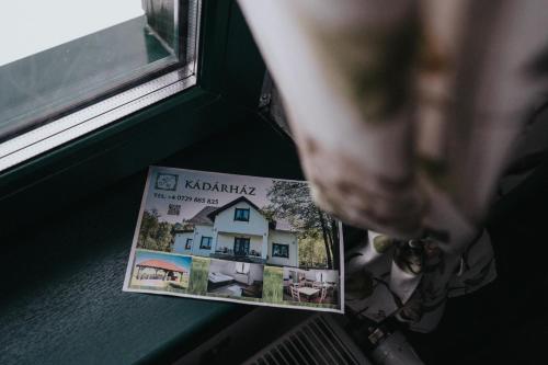 a magazine sitting on a window sill next to a house at Kádárház in Vlăhiţa