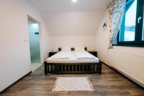 a small bedroom with a bed and a window at Kádárház in Vlăhiţa
