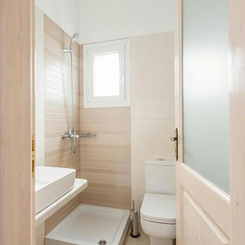 a white bathroom with a toilet and a sink at Ch apartment's Mykonos in Ornos