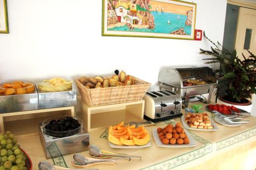 a buffet with fruit and other foods on a counter at Villa Mareblu Luxury Holiday Apartment direttamente sul mare in Stromboli