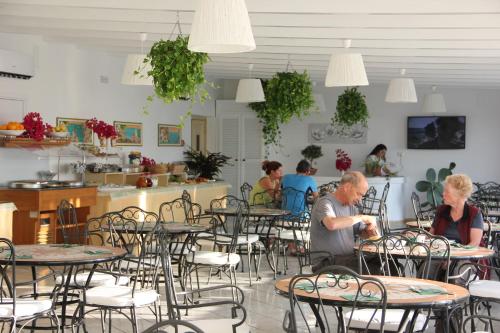 a man and woman sitting at tables in a restaurant at Villa Mareblu Luxury Holiday Apartment direttamente sul mare in Stromboli