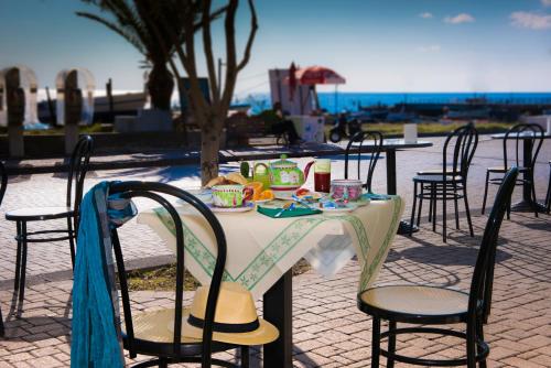 a table with a plate of food on it at Villa Mareblu Luxury Holiday Apartment direttamente sul mare in Stromboli