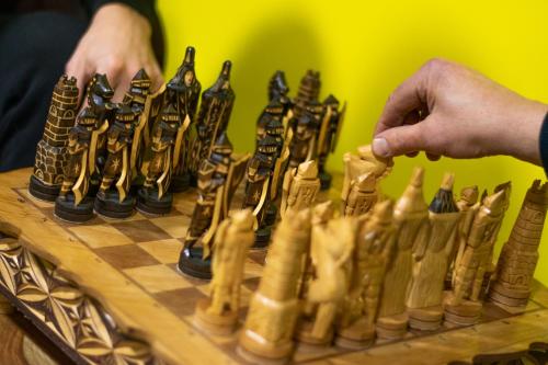 a person playing chess on a wooden chessboard at Very Bad Hootel in Kaunas