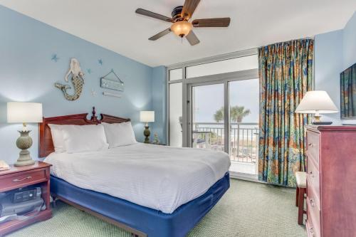 a bedroom with a bed with a ceiling fan and a window at Atlantica Towers Beach-side Condo w Pools in Myrtle Beach