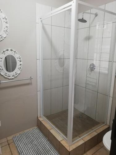 a shower with a glass door in a bathroom at A-Cody Place in Louis Trichardt