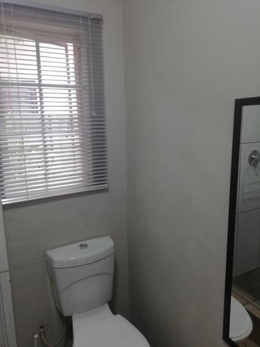 a bathroom with a white toilet and a window at A-Cody Place in Louis Trichardt