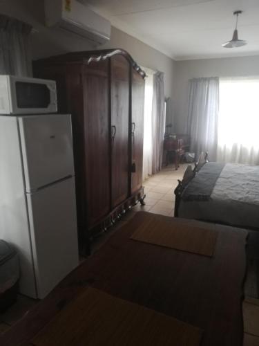a bedroom with a bed and a refrigerator and a bed at A-Cody Place in Louis Trichardt