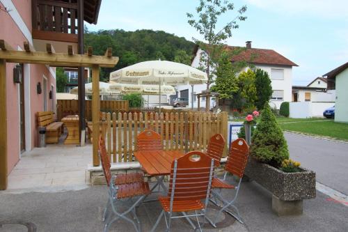 une terrasse avec une table, des chaises et un parasol dans l'établissement Gasthof Rundeck, 
