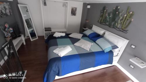 a bedroom with a bed with blue and white pillows at SISTO 85 - HOLIDAY HOUSE in Catania