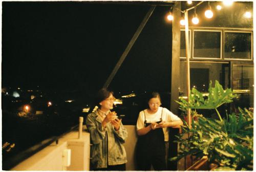 two women standing on a balcony at night at Thung Lũng Mơ - Dream Valley in Khu Chi Lăng