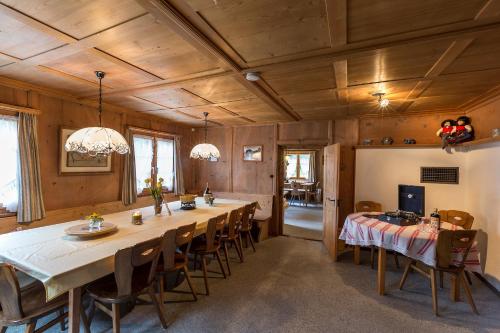 een grote eetkamer met een lange tafel en stoelen bij Cresta - 9,5-Zimmerhaus für 19 - 20 Personen, 270m2 in Conters