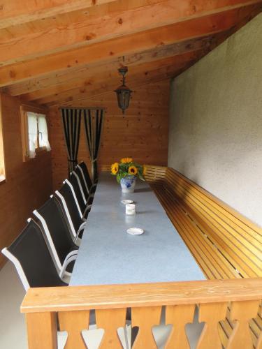 a dining room table with chairs and a vase of flowers at Cresta - 9,5-Zimmerhaus für 19 - 20 Personen, 270m2 in Conters