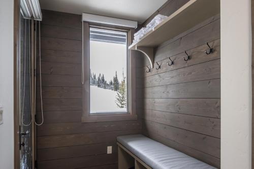 een badkamer met een bankje naast een raam bij Gateway Condo - 15 Wildwood in Big Sky