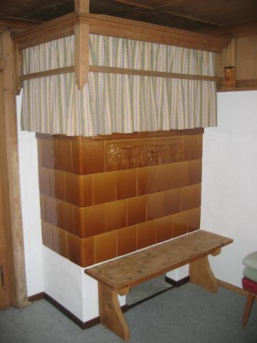 a wooden bench sitting in the corner of a room at Cresta - 9,5-Zimmerhaus für 19 - 20 Personen, 270m2 in Conters
