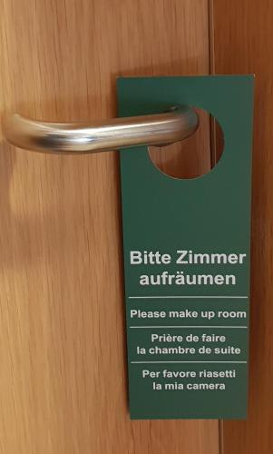 a sign on a wooden door with a door handle at Airport Hotel One Aparthotel Sylt in Tinnum
