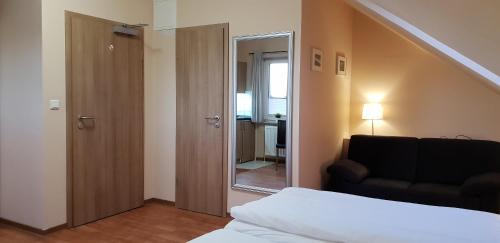 a bedroom with a bed and a chair and a mirror at Airport Hotel One Aparthotel Sylt in Tinnum