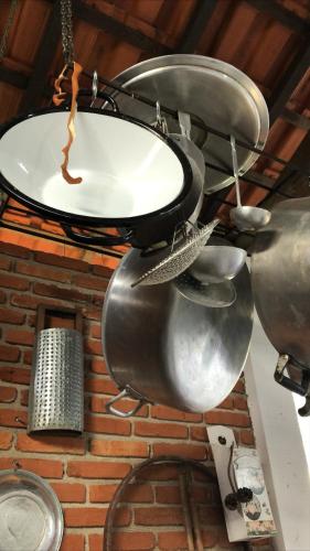 a bunch of pots and pans hanging from a ceiling at Atma Anna in Piedade