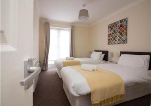 a hotel room with two beds and a window at StayZo Penthouse Accommodation 2- Premier Lodge in Southampton