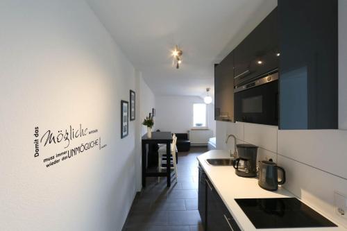 - une cuisine avec un évier et un comptoir dans l'établissement Ferienwohnungen Wiesengrund, à Monschau