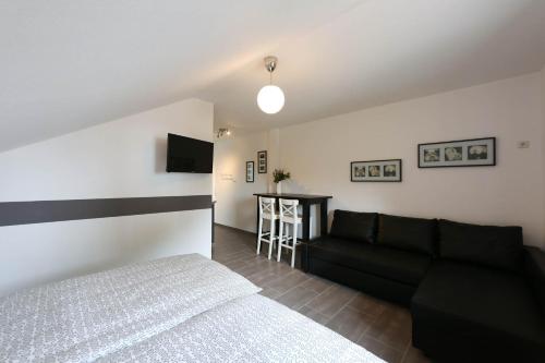 - une chambre avec un lit et un canapé noir dans l'établissement Ferienwohnungen Wiesengrund, à Monschau