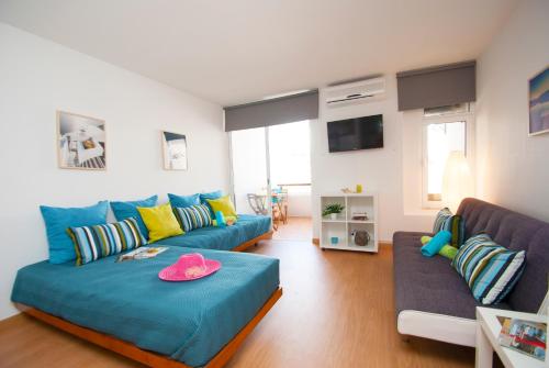 ein Wohnzimmer mit zwei blauen Sofas und einem TV in der Unterkunft Apartment Studio Marbella by Algarve Vacation in Albufeira