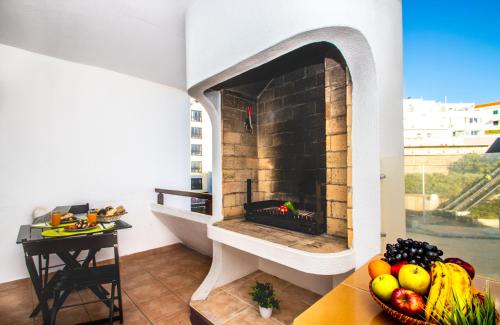 einen Steinkamin im Wohnzimmer mit einer Obstschale in der Unterkunft Apartment Studio Marbella by Algarve Vacation in Albufeira