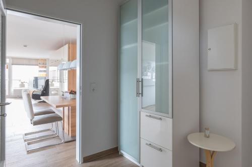 a glass door leading into a kitchen with a table at Christiansen im Panoramahaus Duhnen in Cuxhaven