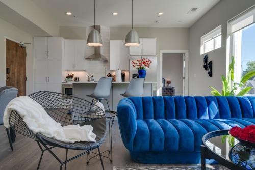 a living room with a blue couch and a kitchen at Mason Lofts at West End in Nashville