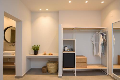 a dressing room with a closet and a mirror at Vigla Hotel in Aegiali